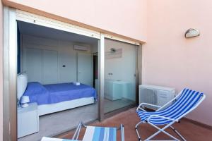 a bedroom with a bed and a chair and a window at Mondello Addaura Home Holiday in Mondello