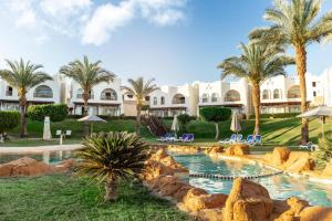 een resort met zwembad en palmbomen bij Private Luxury Villas at Sharm Dreams Vacation Club in Sharm El Sheikh