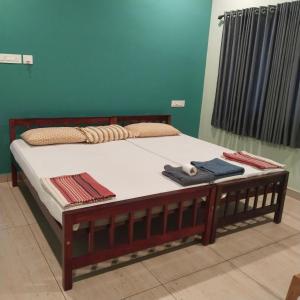 een bed met een houten frame en handdoeken erop bij Cherish homestay in Cochin +24 foto's