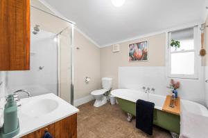 a bathroom with a tub and a sink and a toilet at Clark Cottage in Toowoomba