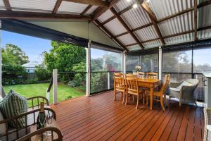 a large deck with a wooden table and chairs at Clark Cottage in Toowoomba