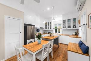 a kitchen with a wooden table and white cabinets at Clark Cottage in Toowoomba +5 photos