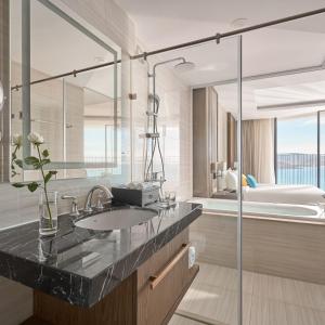 een badkamer met een wastafel, een bad en een douche bij Panorama Nha Trang Sky Beach Residences in Nha Trang