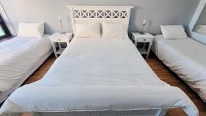 two beds in a room with white sheets and pillows at Amazing View Studio Obelisco in La Porteña