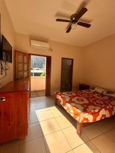 a bedroom with a bed and a ceiling fan at Hostal Luxury Place in Bahía de Caráquez