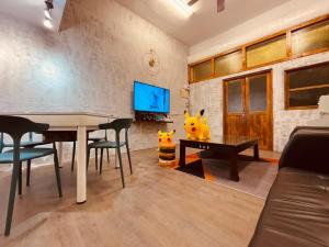 a living room with a table and a tv at Mumian Manlv Homestay in Hengchun South Gate