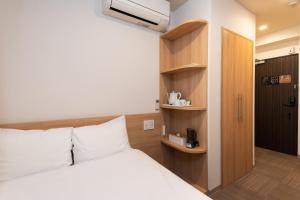 ein Schlafzimmer mit einem Bett und einem Bücherregal in der Unterkunft Hopetree 天王寺 in Osaka