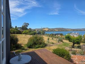 een balkon met een tafel en uitzicht op het water bij Sunrise on the Tamar in Deviot