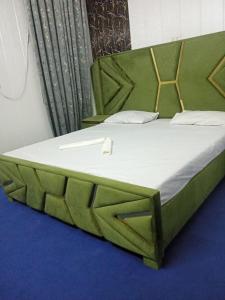 Ce lit se trouve dans un dortoir doté d'un cadre de lit vert. dans l'établissement Al IMRAN villa 2 bedroom apartment, à Lahore
