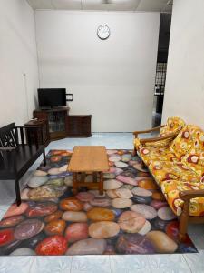 a room with a couch and a table on a carpet at HOMESTAY NO.45 in Jitra