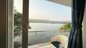 a view of a lake from a window at Riverfront Grand By GikiJoy in Siolim