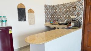 a kitchen with a counter top and a wall at Riverfront Grand By GikiJoy in Siolim
