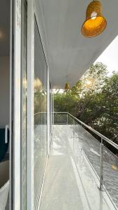 a balcony of a house with a glass railing at Riverfront Grand By GikiJoy in Siolim +13 photos