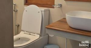 een kleine badkamer met toilet en wastafel bij nelli house in Galle