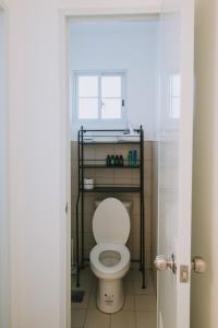 une salle de bain avec des toilettes avec une étagère au-dessus dans l'établissement Villa Serena, à Dauis