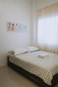 un lit dans une chambre blanche avec une fenêtre dans l'établissement Villa Serena, à Dauis