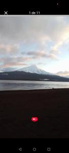 een rode frisbee op het strand met een berg bij Cabañas Loley - a pasos del lago in Puerto Varas +2 foto's