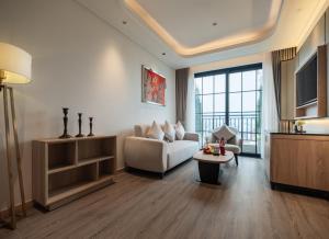 een woonkamer met een bank en een tafel bij HOTEL du LAC SIGNATURE in Hanoi