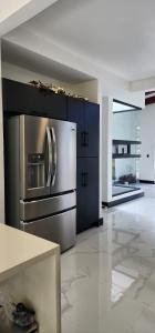 a kitchen with a stainless steel refrigerator and cabinets at Residential Finca Celeste in Bijagua