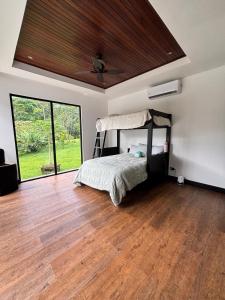 a bedroom with a bed with a wooden ceiling at Residential Finca Celeste in Bijagua