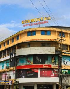a yellow building with a sign on top of it at Rockmont Inn in Taliparamba