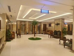 a lobby with a palm tree in the middle of a building at فندق الكشاف المتقدم توصيل للحرم مجاني in Mecca