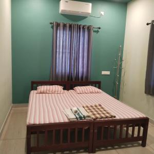 een bed in een kamer met roze lakens en een raam bij Cherish homestay in Cochin