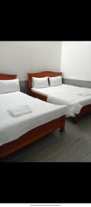 zwei Betten nebeneinander in einem Zimmer in der Unterkunft Nhà Nghỉ Quỳnh Thoa in Mỹ Tho + 5 Fotos