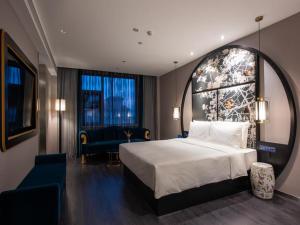 En eller flere senge i et værelse på Orange Crystal Hotel Qingdao Jimo Ancient Town