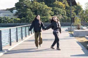 two people walking on a bridge holding hands at Kaigetsu in Toba