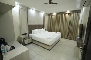 a hotel room with a bed and a television at Time Square Inn in Erāttupetta