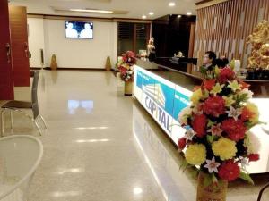 eine Lobby mit einer Theke mit Blumen darauf in der Unterkunft The Capital Hotel in Roi Et