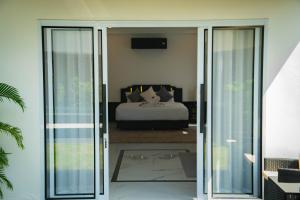 a bedroom with a bed and a sliding glass door at Phangan Cove Pool Villas in Srithanu