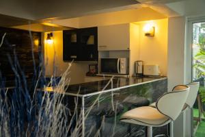 a kitchen with two chairs and a counter with a counter top at Phangan Cove Pool Villas in Srithanu