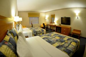 ポサ・リカ・デ・イダルゴにあるRio Vista Inn Business High Class Hotel Poza Ricaのベッド2台、薄型テレビが備わるホテルルームです。