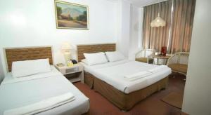 een hotelkamer met twee bedden en een tafel bij Hotel Supreme in Baguio