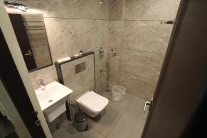 a bathroom with a sink and a toilet and a mirror at Time Square Inn in Erāttupetta