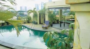 ein Haus mit einem Swimmingpool in der Mitte eines Gebäudes in der Unterkunft Grand Cemara Hotel in Jakarta