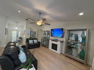 een woonkamer met een leren bank en een tv bij Coastal Launch Properties in Titusville