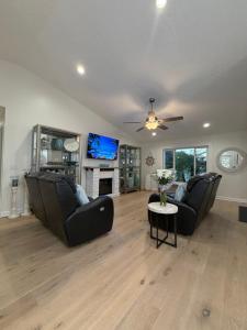 een woonkamer met twee banken en een tv bij Coastal Launch Properties in Titusville