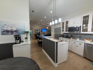 a kitchen with white cabinets and a dining room at Near KSC - Peaceful Spacious Home for 6 - Fully Stocked Kitchen and Coffee Bar in Titusville