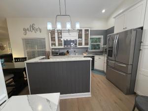 een keuken met een roestvrijstalen koelkast en witte kasten bij Coastal Launch Properties in Titusville +21 foto's