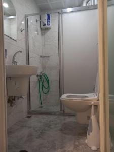 a bathroom with a shower and a toilet and a sink at Hotel Anadolu in Finike