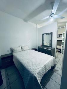 een slaapkamer met een bed en een plafondventilator bij Adonai in Rincon de Guayabitos