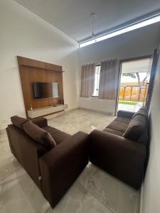 un salon avec un canapé et une télévision à écran plat dans l'établissement Casa alegre, à Belo Horizonte