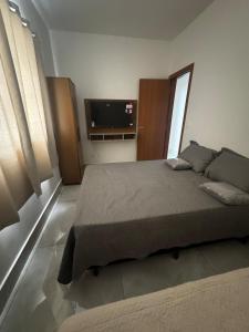 une chambre avec un lit et une télévision à écran plat dans l'établissement Casa alegre, à Belo Horizonte