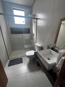 une salle de bain blanche avec un lavabo et des toilettes dans l'établissement Casa alegre, à Belo Horizonte