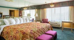 een hotelkamer met een groot bed en paarse stoelen bij Rodeway Inn & Suites in Tupelo