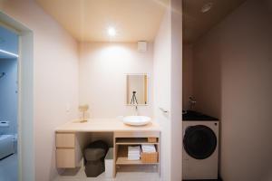 ein Badezimmer mit Waschbecken und Waschmaschine in der Unterkunft Mimi Hakuba by Jade Villa in Hakuba + 12 Fotos