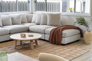 ein Wohnzimmer mit einer weißen Couch und einem Tisch in der Unterkunft Mare Mio Callala Beach Jervis Bay in Callala Beach + 37 Fotos